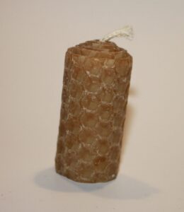 Handgerollte Bienenwachskerze aus einer Mittelwand mit natürlichem Wabenmuster.